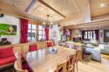 Experience the charm of this stunning property, featuring a warm and inviting dining area with a large wooden table, perfect for gatherings.
