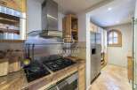 Discover the charm of this kitchen, featuring a stainless steel range hood and a sleek cooktop.