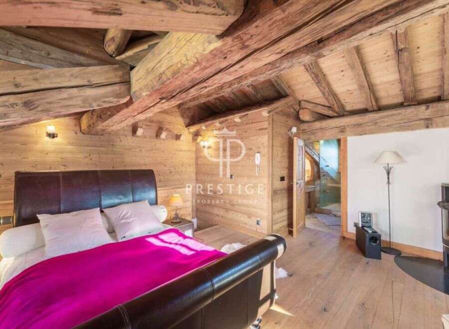 Experience rustic charm in this stunning bedroom featuring exposed wooden beams and paneling.