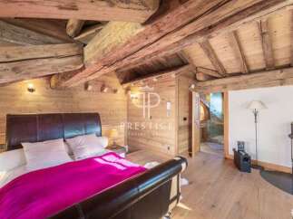 Experience rustic charm in this stunning bedroom featuring exposed wooden beams and paneling.
