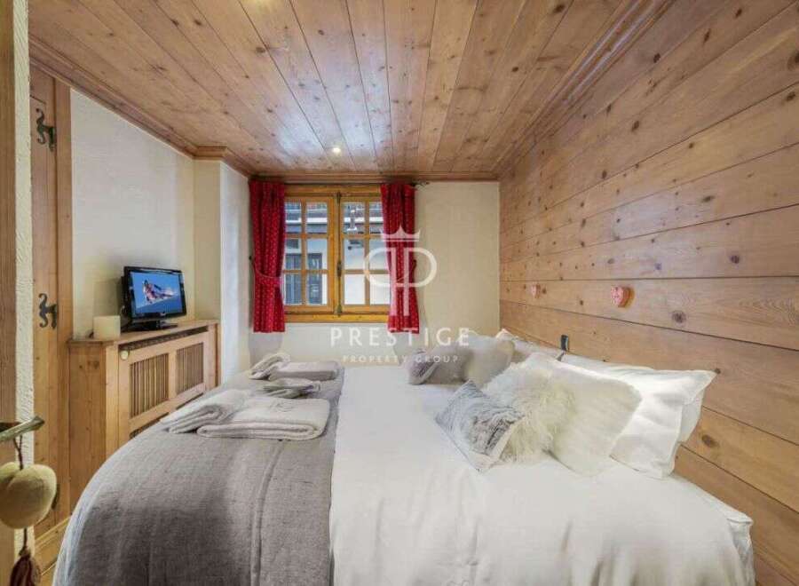 Experience rustic charm in this cozy bedroom, featuring warm wooden walls and ceiling.
