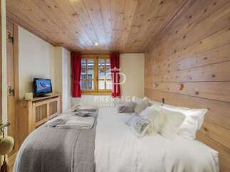 Experience rustic charm in this cozy bedroom, featuring warm wooden walls and ceiling.