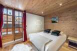 Experience the charm of this cozy bedroom, featuring a warm wooden ceiling and walls.