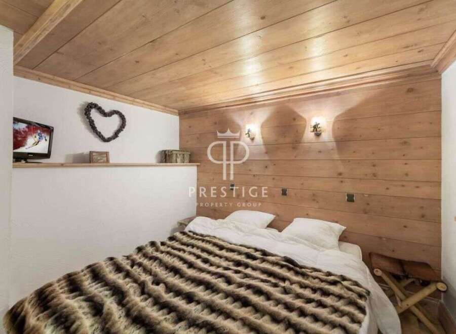 Cozy bedroom with wooden paneling and a warm, inviting atmosphere.