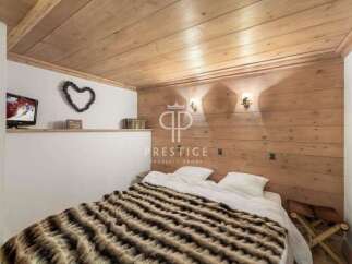Cozy bedroom with wooden paneling and a warm, inviting atmosphere.