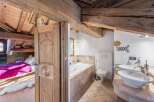 Discover the charm of this rustic property, featuring a cozy bedroom with a vibrant pink bedspread.