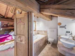 Discover the charm of this rustic property, featuring a cozy bedroom with a vibrant pink bedspread.