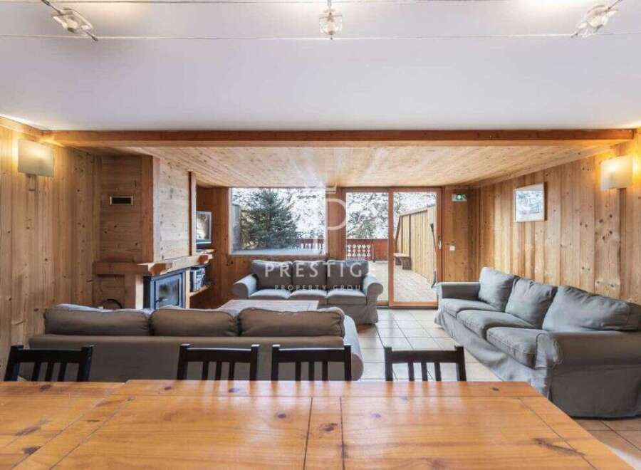 Experience the warmth of this inviting living space, featuring stunning wooden paneling and a cozy fireplace.