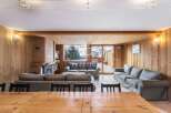 Experience the warmth of this inviting living space, featuring stunning wooden paneling and a cozy fireplace.