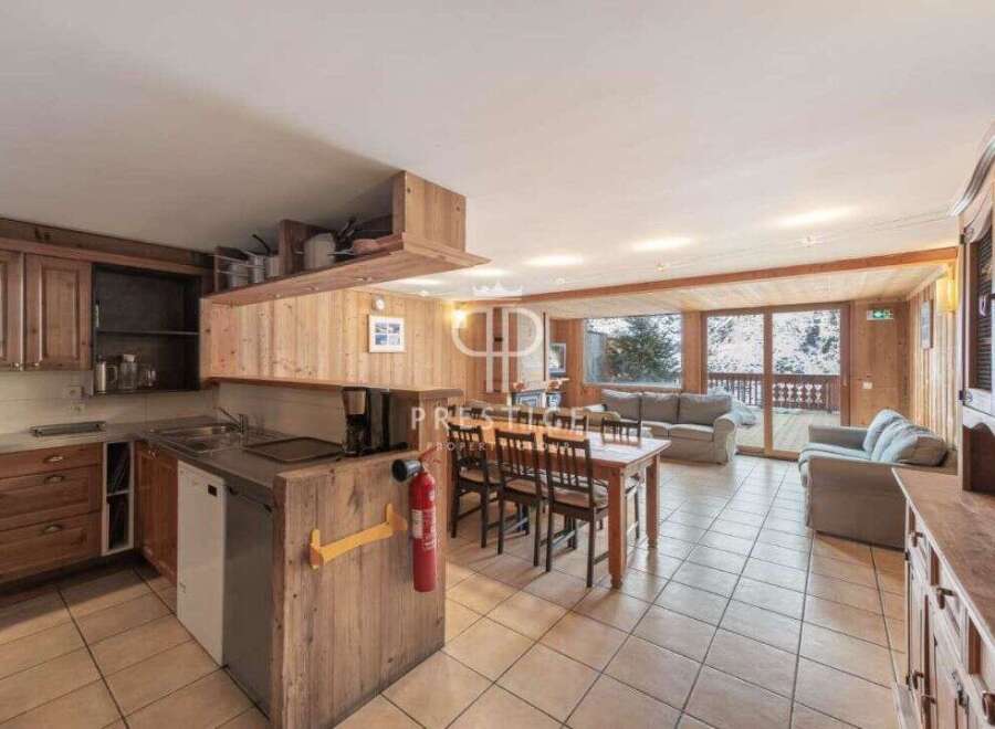 Discover the charm of this cozy property, featuring a warm wooden interior and a spacious open-plan living area.
