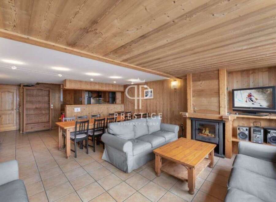 Discover the charm of this cozy living space, featuring a warm wooden interior and a welcoming fireplace.