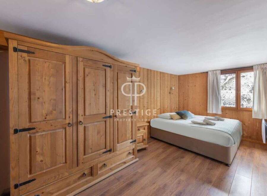Discover the charm of this cozy bedroom, featuring stunning wooden paneling and a spacious wardrobe.