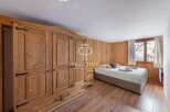 Discover the charm of this cozy bedroom, featuring stunning wooden paneling and a spacious wardrobe.