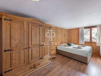 Discover the charm of this cozy bedroom, featuring stunning wooden paneling and a spacious wardrobe.