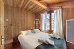 Experience the charm of this cozy bedroom, featuring warm wooden walls and a rustic ceiling.