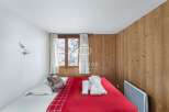 Cozy bedroom with a rustic wooden accent wall.
