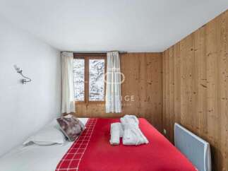Cozy bedroom with a rustic wooden accent wall.
