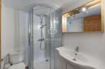 Discover a modern bathroom with a sleek shower enclosure and a stylish vanity.