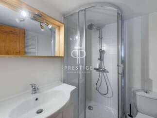 Discover a modern bathroom with a sleek shower enclosure and a stylish vanity.