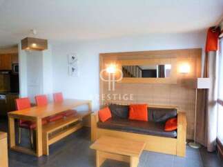 This cozy living space features a stylish wooden dining table with matching chairs and bench, perfect for family meals.