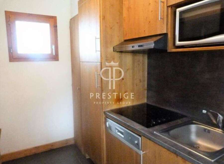 Discover a cozy kitchen with wooden cabinets and a sleek countertop.