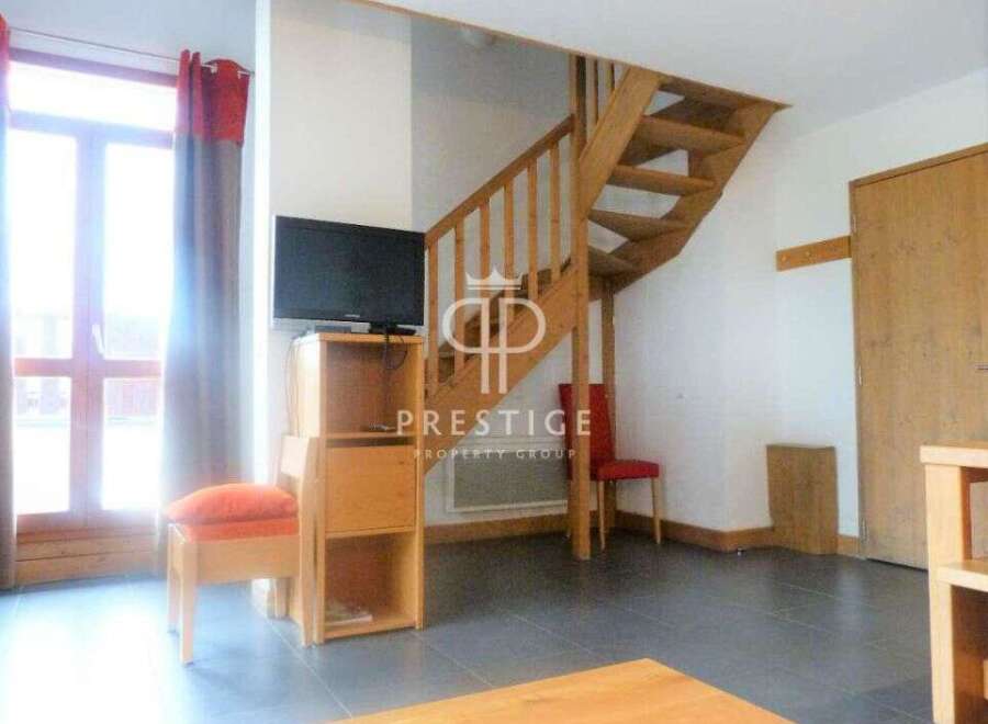 Discover this charming property featuring a cozy living space with a staircase leading to the upper level.