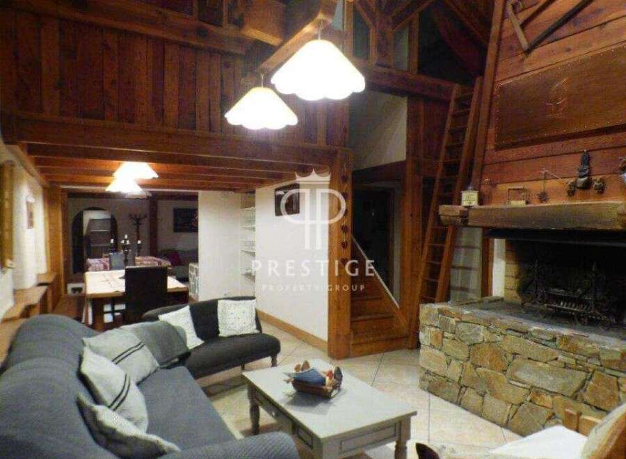 Discover the charm of this stunning property, featuring a cozy living room with a fireplace and exposed wooden beams.