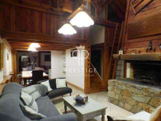 Discover the charm of this stunning property, featuring a cozy living room with a fireplace and exposed wooden beams.
