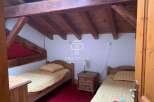 Discover a charming bedroom with rustic wooden beams and cozy single beds.