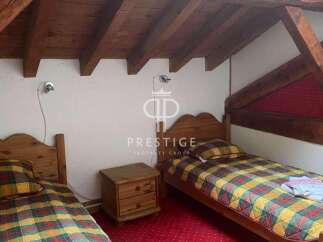 Charming bedroom with rustic wooden beams and cozy twin beds.