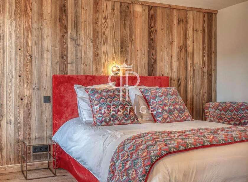 Experience luxury in this stunning bedroom featuring a vibrant red headboard and a cozy, patterned bedspread.