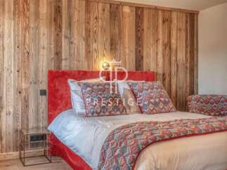 Experience luxury in this stunning bedroom featuring a vibrant red headboard and a cozy, patterned bedspread.