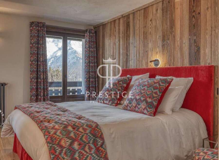 Experience luxury in this stunning bedroom featuring a cozy bed with vibrant pillows and a plush red headboard.