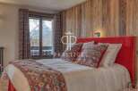 Experience luxury in this stunning bedroom featuring a cozy bed with vibrant pillows and a plush red headboard.