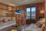 Experience luxury living in this stunning property, featuring a cozy living room with a beautiful wooden wall.
