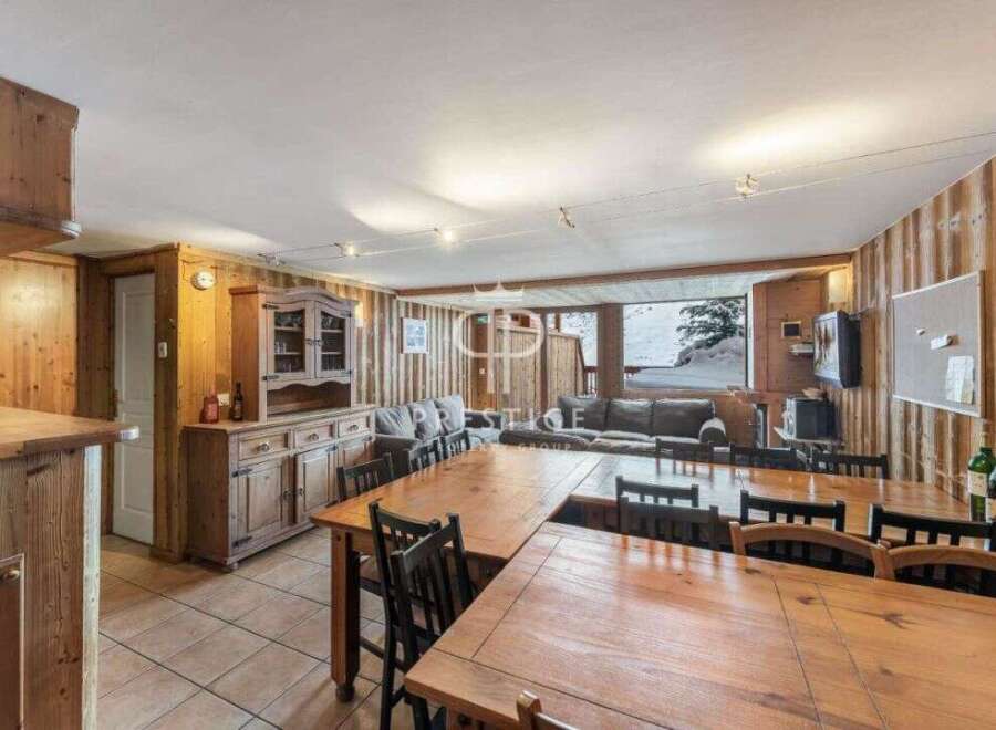 Discover the charm of this cozy property, featuring warm wooden interiors and a spacious dining area perfect for gatherings.