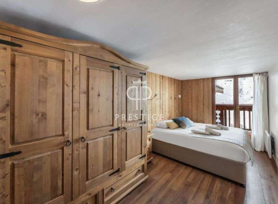 Discover a cozy bedroom retreat featuring a stunning wooden wardrobe and warm wooden paneling.
