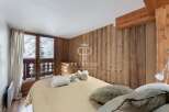 Cozy bedroom with wooden paneling and a balcony overlooking a snowy landscape.