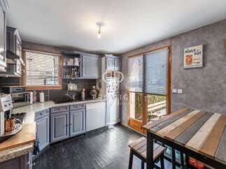Discover this charming kitchen with its stylish gray cabinetry and sleek black countertops.
