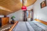 Discover the charm of this cozy bedroom, featuring a unique sloped wooden ceiling and a warm, inviting atmosphere.