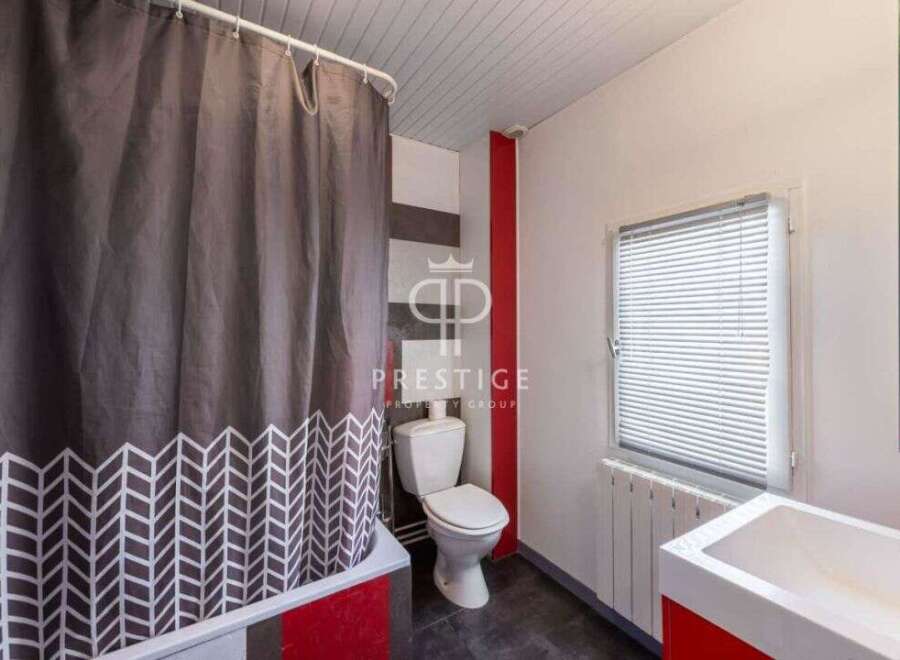 Discover this charming bathroom featuring a stylish shower curtain with a unique pattern.
