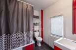Discover this charming bathroom featuring a stylish shower curtain with a unique pattern.