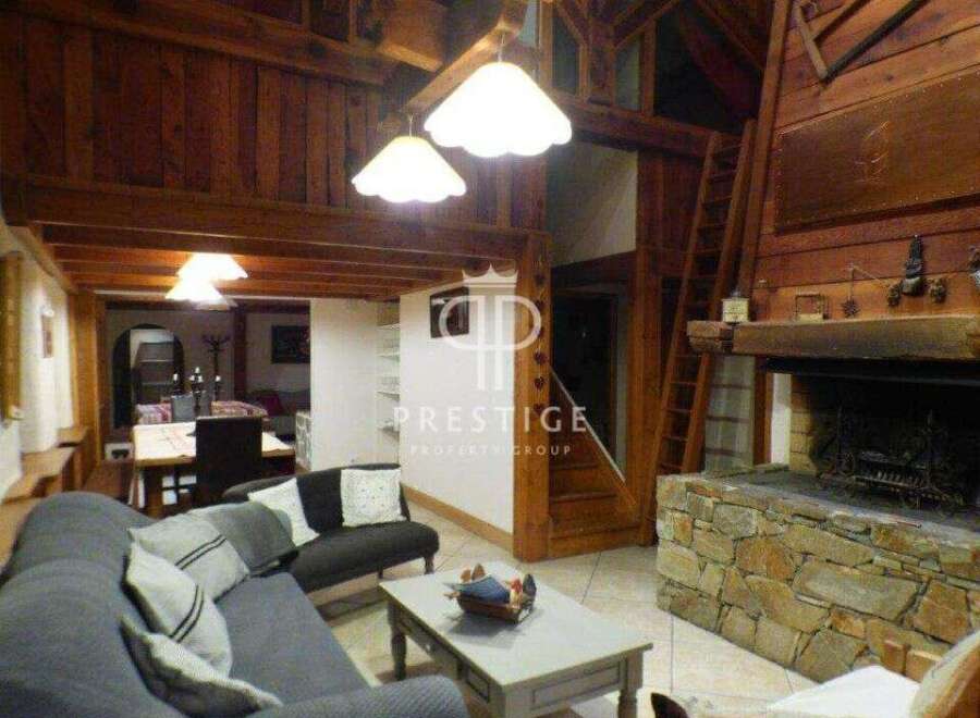Discover the charm of this stunning property, featuring a cozy living room with a fireplace and exposed wooden beams.