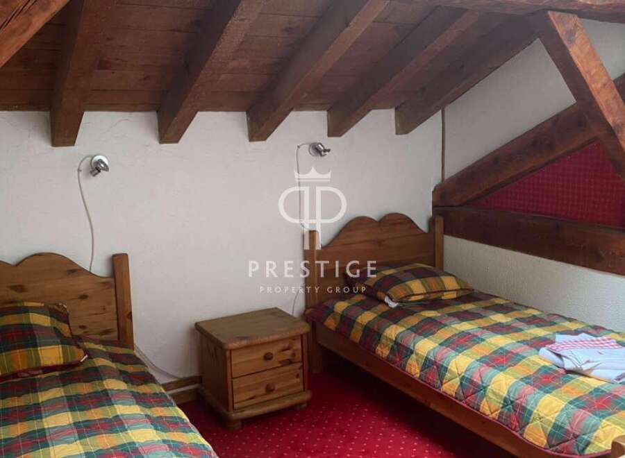 Charming bedroom with rustic wooden beams and cozy twin beds.
