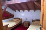 Discover a charming bedroom with rustic wooden beams and cozy single beds.