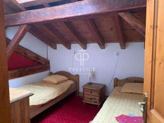 Discover a charming bedroom with rustic wooden beams and cozy single beds.