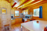 Step into this charming cabin kitchen, featuring warm wooden accents and a cozy atmosphere.