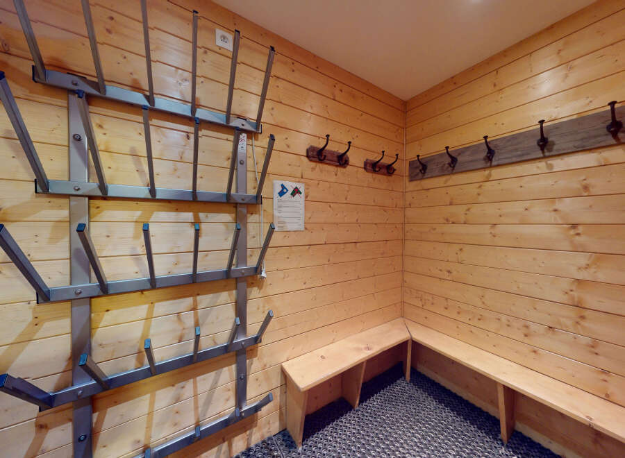 This cozy ski room features wooden walls and benches, perfect for storing and organizing your gear.