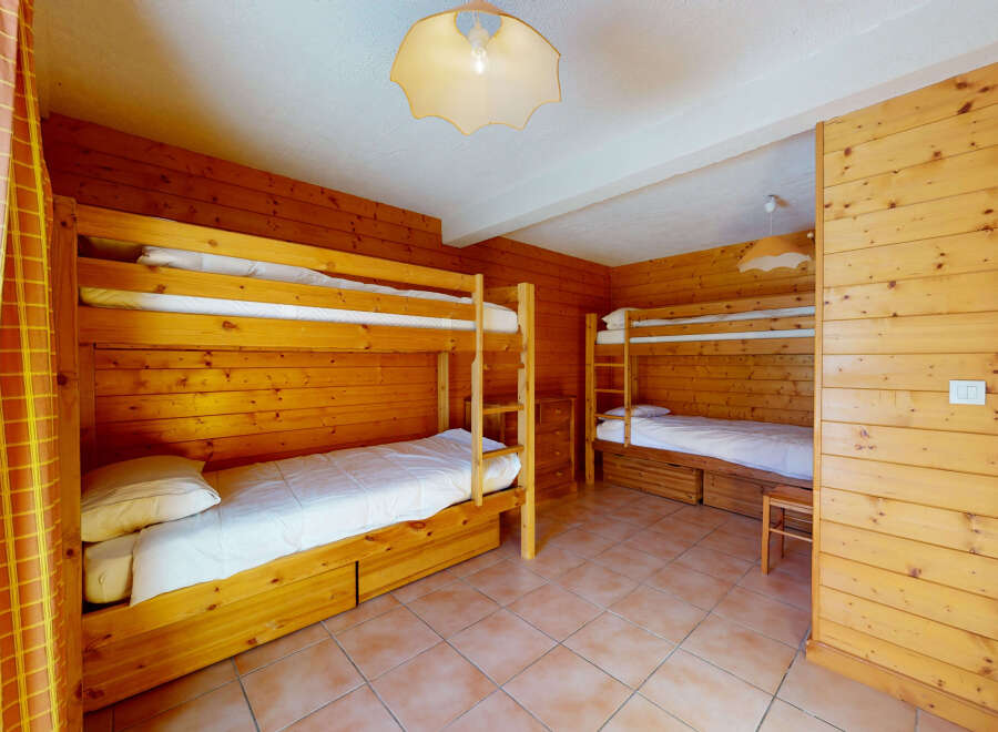 This cozy bedroom features two sets of bunk beds, perfect for accommodating a family or group of friends.