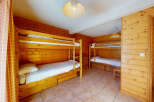 This cozy bedroom features two sets of bunk beds, perfect for accommodating a family or group of friends.